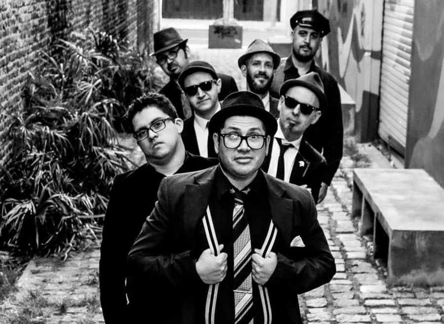 Kato Ska: "Apelamos a la necesidad artística de unificar dos mundos diferentes" - Abordando el estilo del ska británico y jamaicano desde el 2014, Kato Ska se completa con los nueve integrantes que actualmente llevan adelante el proyecto: Maximiliano "Kato" Delmás en guitarra y voz; Rubén "Topo" Domínguez en guitarra y coros; Leandro "Lea" Bertoni en bajo; Nahuel "Palmer" Sosa en saxo tenor; Lucas "Bambino" Canepa en saxo alto; Fabián "Fafa" Morresi en trombón; Gustado "Dino" Tarditti en trompeta; Alexis "Pity" Bonafert en batería; y Dante Clementina en teclados. Kato Ska