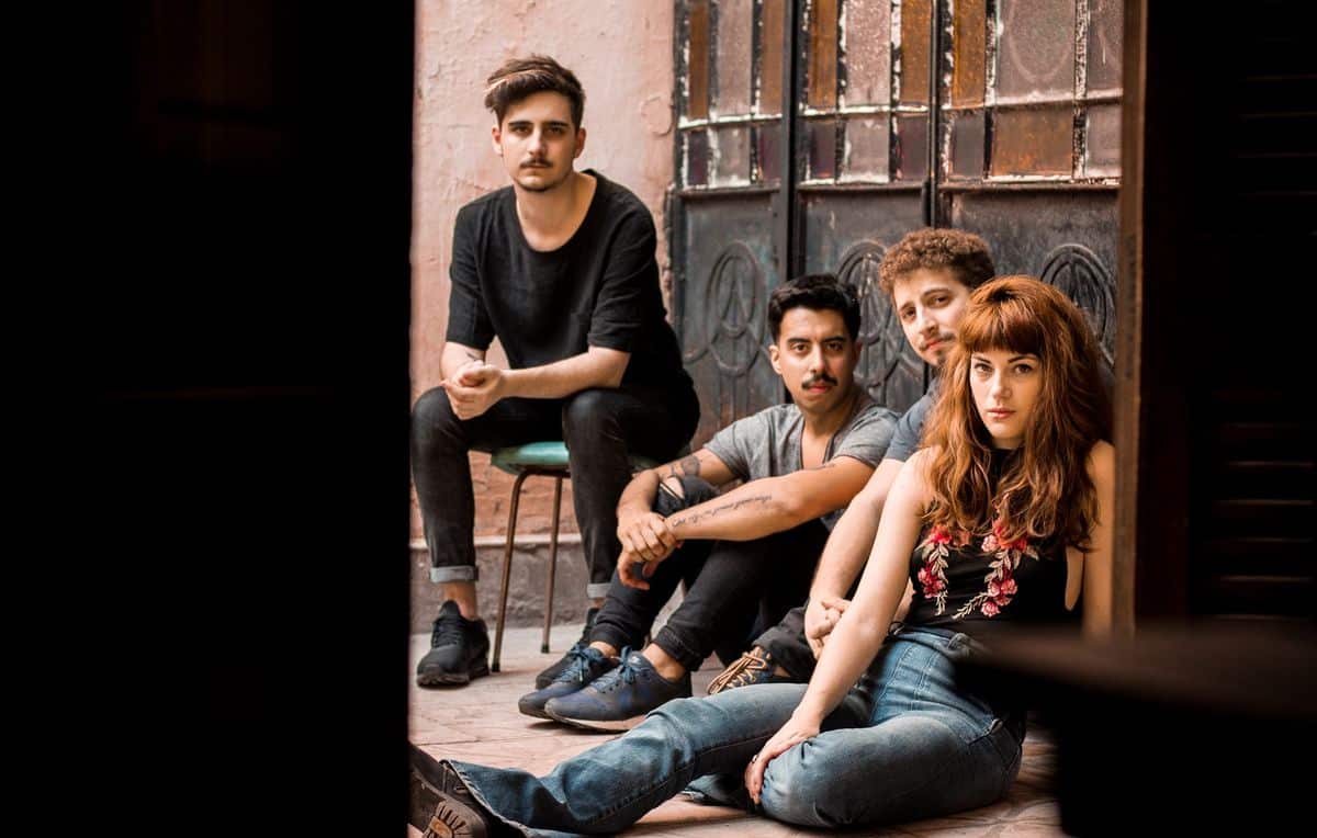 Sobreviento adelanta parte de su nuevo disco en El Emergente de Almagro - Después de celebrar sus primeros 5 años de recorrido musical y autogestión, Sobreviento se encuentra finalizando la grabación de su nuevo disco. Su gestación y producción tuvieron el apoyo de la Beca a la Creación del Fondo Nacional de las Artes (FNA) y el subsidio a la producción del Instituto Nacional de la Música (INAMU). Las nuevas composiciones buscan la expresividad de la canción, sin dejar de lado el afán por las formas novedosas en el sonido y la interpretación. La producción artística se encuentra a cargo de Juan Saraco (Duratierra). El proyecto musical actualmente lo conforman Flor Wosh en voz; Sebastián Verdún en bajo; Pablo Boyé en guitarra y Agustín Piva en batería; poniendo énfasis tanto en la canción, como en la búsqueda constante de nuevos sonidos y nuevas texturas. ¿En qué momento, a nivel banda y personal, se encuentra Sobreviento? Estamos en un momento que es muchos momentos a la vez. Se trata de una etapa de consolidar un poco lo que venimos trabajando hasta hoy. La propuesta estética de la banda, nuestro sonido en vivo, la organización que nos venimos dando y también de consolidación como grupo. A su vez, es un momento de transición hacia lo nuevo donde nos encontramos con una identidad que está mutando. Las nuevas canciones se diferencian muy marcadamente de nuestro primer disco y es un desafío porque hay que hacerse cargo. Lo que somos se transforma constantemente porque nosotros mismos cambiamos. Aprendemos cosas nuevas, conocemos gente nueva y los contextos cambian. El momento actual es de mucha incertidumbre y preocupación. Estamos viviendo una coyuntura bastante oscura y un panorama que se avizora aún peor. Ante eso tenemos que ser creativos, mantenernos activos, organizados y seguir apostando a generar cosas nuevas desde lo colectivo. ¿Qué representa este último material que están preparando? Representa un quiebre, sin dudas. El proceso de este disco que estamos terminando de grabar, y que verá la luz el año que viene, tiene cerca de un año y medio de trabajo. Implicó repensar de raíz cómo laburar las composiciones, cómo entendernos en relación con las canciones y con lo que buscamos transmitir. Un punto clave es pensar la canción desde su lugar emotivo. También asumir que el momento que estamos viviendo precisa de mayor claridad. Se dio una búsqueda muy precisa respecto de cómo encarar las letras que implicó un trabajo poético, narrativo y de ir al hueso. Interpelar, esa es otra palabra clave. Entender que hay un vínculo inescindible entre la música y el cuerpo. Y todo este laburo desde el momento cero lo llevamos adelante con Juan Saraco, que es también el productor artístico del disco. ¿Cómo se dio el apoyo de la Beca a la Creación del FNA y el subsidio a la producción del INAMU? Simplemente presentamos los proyectos en los organismos y en ambos casos fueron aprobados. Resultó importantísimo para nosotros porque producir un disco implica muchísimo trabajo, tiempo y dinero. Entonces, contar con un apoyo económico siempre es un factor positivo. Además, nos parece fundamental destacar la importancia de que existan instituciones como estas. El acceso a la cultura y a la producción cultural es un derecho que el Estado debe garantizar. Sobre todo en aquellos rubros o espacios a los que el mercado ni siquiera mira de reojo. Sino sólo aquellos que tienen las condiciones materiales salen adelante. También es importante hacer hincapié en la defensa de esos espacios ante las políticas económicas regresivas como las que nos toca vivir hace tres años. ¿Cómo planean desarrollar la fecha en El Emergente? Queremos que sea una celebración. Fue y es un año muy intenso y duro en muchos niveles. Claramente no sólo para nosotros. Así y todo, creemos que sobran los motivos para seguir encontrándonos y celebrando con alegría. En nuestro caso, la mejor forma de hacerlo es compartiendo música, y sobre todo, la que estamos trabajando en este último tiempo. Desde ya que adelantaremos varias de las canciones nuevas y habrá músicos amigos invitados a compartir escenario. La idea es que sea un show cargado de mucha energía e intensidad. Siempre que cerramos el año en El Emergente apostamos a una propuesta fuerte. No sólo desde el sonido, sino también desde lo visual. Y cada año sumamos algún condimento nuevo. Queremos que sea un espectáculo, en el sentido grande de la palabra. ¿Cómo describirían la propuesta en vivo? En los últimos años logramos consolidar una propuesta sólida y contundente, donde fluyen diferentes emociones. Se trata siempre de un show cargado de intensidad. Aspiramos a un vivo que interpele al oyente y, a partir de ahí, generar un diálogo. ¿Qué los diferencia o destaca de otras? Más que en diferenciarnos, en realidad siempre tratamos de usar como referencia inspiradora aquellas movidas que logran dejar algo más que canciones. Tratar de reconocer un estilo propio y explotarlo artísticamente a favor de las emociones que queremos transmitir. Con más o menos recursos, siempre el norte es tratar de que las canciones estén acompañadas de un clima sonoro y visual que las haga crecer. Pondremos todos los recursos que tenemos a nuestro alcance para hacer de la fecha del 30 de noviembre una nueva propuesta de encarar las canciones. ¿Cuáles son los pro y contras al momento de llevar adelante un material y organizarse con las giras desde la autogestión? La autogestión es la forma que encontramos, al mismo tiempo que es la forma que nos encontró a nosotros. Es decir, hoy en día es más una necesidad que una decisión. Se vuelve una decisión cuando se le da un contenido diferente que se aleja de las lógicas del mercado y de las antiguas nociones de “exitismo”. Que aspira a mayores niveles de horizontalidad y de solidaridad. Que genera lazos genuinos y duraderos, tanto entre músicos como con los públicos y gestores. Desde ya que las decisiones, en términos artísticos, son de mayor autonomía. Pero también es importante no confundir autogestión con precarización porque es en esos márgenes más amplios de libertad que te volvés gestor de tus propios proyectos. Y no sólo trabajar lo artístico, sino también lo logístico, lo comunicacional, la prensa y la producción. Hay un punto en el que, además, recae sobre el músico una multiplicidad de tareas que en realidad deberían ocupar otras personas. ¿Cómo seguirá la grilla de fechas para los próximos meses? La fecha del 30 de noviembre en El Emergente será la última del año y no tocaremos más hasta la presentación del disco en 2019. b9665514 cdc6 4b70 b9f8 0c8eae3fe2c0