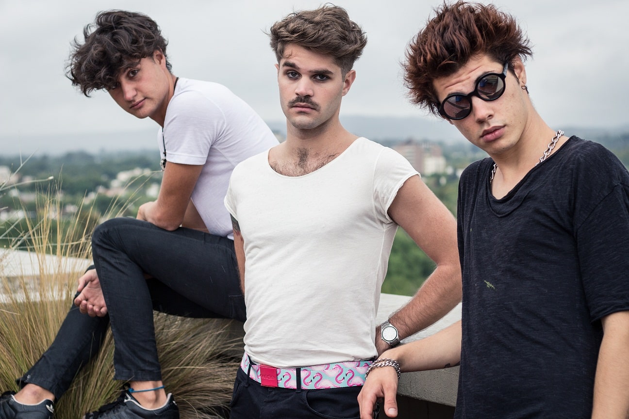 Trílicos: "El éxodo es un estímulo para la inspiración" - El trío mendocino cambió de nombre, lanzó álbum homónimo y un nuevo single independiente a este material, todo durante el mismo año, y desde hace algunos meses sus integrantes se radicaron en Buenos Aires. “El éxodo es un estímulo para la inspiración –afirma el bajista Padi Andresen de 21 años–. Separarte de tus amigos, familia, amores, barrio y aparecer en una ciudad enormemente solitaria es una prueba jodida. La música nos rescató de varias”.
El joven trío se completa con Francisco Montilla (voz y guitarra) de 19 y Andrés Nelson (batería) de 18. Los primeros pasos de lo que hoy es Trílicos se dieron en 2008 bajo el nombre de Medieval Society y lanzaron “26 de febrero” a una temprana edad.
“Es una etapa de nuestra vida más que de nuestra profesión, los 13-14 es un momento de cambio muy groso para la existencia, es un placer haberlo vivido en banda y haberlo contado con canciones”, señala Padi. Fue durante la producción del que sería el segundo álbum cuando decidieron mutar la identidad. Para el bajista, el material homónimo que vio la luz a comienzo de 2016 es un disco que nació en base a las complicaciones que aparecen en el mundo de todo preadolescente y agrega: “el cambio es radical en lo que es artístico y de producción, pero la esencia energética y fresca por suerte la pudimos mantener”.
Con esa velocidad que identifica a la juventud, Trílicos lanzó inmediatamente un nuevo simple para cerrar el 2016: “Creamos por jugar porque es lo que nos sale –explica–. Hacemos temas juntos todo el tiempo, tres cabezas componiendo ayuda a que haya material fresco siempre. ‘Tu veneno’ es un single que salió porque sí, es una obra individual diferente a ‘Trílicos’ álbum y a lo que vendrá”.
Desde este año, Francisco, Andrés y Padi decidieron mudarse a Buenos Aires para llevar adelante su futuro material: “Es una ciudad oscura pero infinita, te da una dinámica ideal para dedicarte al mercado cultural. La banda es una búsqueda constante, un objetivo común y animal que los tres perseguimos. Por esa forma de pensar es que estamos viviendo y experimentado la convivencia total”, explica el encargado de las cuatro cuerdas y adelanta sobre un próximo disco que ya hay muchas ideas y sonidos y concluye: “Vivir los tres juntos, flashear comunidad en muchos aspectos, y la sinergia que se ha generado ha influido muchísimo en la composición. Por ahora no queremos etiquetarlo ni ponerle adjetivos, sobre todo porque es un laburo de todos los días y el porvenir es hermosamente impredecible”. 285a5ab1 dc02 4570 bd3f 2e6affd08086