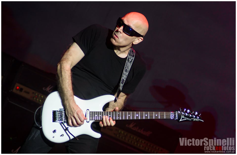 Joe Satriani volvió a la Argentina - Joe Satriani sabe de rock n' roll. Porque Joe Satriani no solo toca la guitarra, no solo ejecuta frases y ligados imposibles haciéndolos parecer la actividad humana más sencilla. No. Joe Satriani es quizás el único guitarrista de los llamados 'virtuosos' que ha logrado que sus piezas sean canciones: simples (y complicadas) canciones en las que esa guitarra que hace las veces de melodía principal puede ser, en cualquier momento, reemplazada por una voz cantante que probablemente transmitirá con palabras exactamente las mismas sensaciones que Satriani logra transmitir con su tenue caricia sobre las cuerdas. 138e3994 f4c4 4554 a890 cc8bb799f6f3