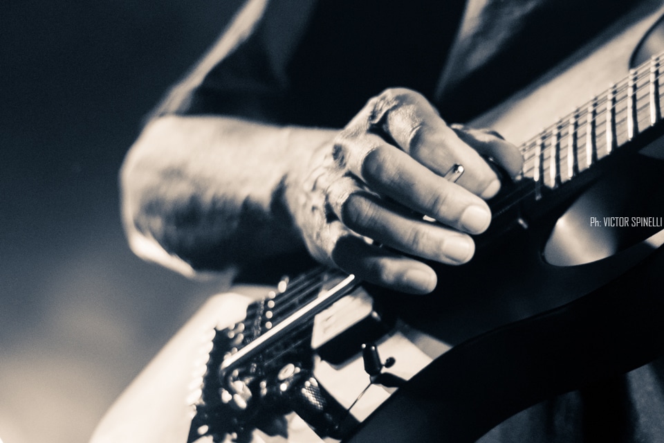 Tony Macalpine deslumbró en el Roxy - El guitarrista estadounidense llegó a la Argentina para presentar "Death of Roses", su disco más reciente. Si no proponemos pensar en guitarristas virtuosos, por lo menos al principio, nos vienen a la cabeza siempre los mismos tres o cuatro: Steve Vai, Joe Satriani, Yngwie Malmsteen, algunos de los más populares a nivel mundial, suelen ser los primeros en asaltar la memoria cuando repasamos el catálogo de maestros de las seis cuerdas. Sin embargo, hay muchos más, y Tony Macalpine en especial, está - a pesar de ser prácticamente un desconocido para el gran público - entre los más respetados y queridos tanto entre sus colegas como entre el público del estilo. Con quince discos solistas en su haber y un enorme inventario entre bandas full-time y colaboraciones con otros artistas, el guitarrista oriundo de Springfield, pionero del metal neo-clásico instrumental es, además, uno de los más prolíficos.
Luego de visitar nuestro país hace algunos años como parte de la banda en vivo de Steve Vai, Macalpine volvió a pisar suelo local, esta vez la primera vez en plan solista – ahora como trío, acompañado por los gigantes Pete Griffin (bajo) y Gergo Borlai (batería) -, para presentar su último trabajo de estudio y festejar, además, el cumpleaños número treinta de Maximum Security (1987), disco que, a fines de los 80, lo puso definitivamente en el podio junto a los mejores de su generación.
Y, a decir verdad, el apartado Death of Roses (2017) fue casi una excusa, un trámite para lo otro: rozando apenas el tracklist de su álbum número quince (sonaron “Chrome Castles”, “Death of Roses”, y alguna más del extenso archivo), el plato fuerte no fue otro que la interpretación, de punta a punta y con apenas alguna pausa para agradecer, del enorme Maximum Security. Así, desde pocos minutos después de comenzado el show, la emocionada audiencia disfrutó de clásicos como “Autumm Lords”, “Hundreds of Thounsands”, las tarareadas “Tears of Sahara” y “Keys to the City” o la preciosa “Porcellain Doll”.
A pesar de un volumen en ocasiones demasiado alto (contratiempo que, al parecer, se repitió en otras fechas del tour, como el Santiago ProgFest, en Chile) y que, por momentos, dificultaba incluso seguir las melodías, el saldo fue el de un show en todo sentido memorable. La visita del artista a tierras argentas dejó como resultado solo alegría y regocijo, abundantes vítores y cánticos de aliento, varios “una más y no jodemos más”, otros tantos “olé olé olé, Tony, Tony” y, sobre todo, grandes emociones, no solo por la performance, indudablemente impecable: es que, hace apenas tres años, el músico se vio obligado a suspender una gira al detectársele un agresivo cáncer del colon que lo tuvo, literalmente, más cerca del arpa que de la guitarra. Y hoy, quizás gracias a la divina intervención de Apolo (aunque más probablemente gracias a la oportuna práctica de algún también virtuoso profesional de la medicina), tuvimos la invaluable oportunidad de verlo y escucharlo, no solo en el mejor de los estados de salud, si no brindándose completamente a su público, en un concierto simplemente inolvidable. 30a80716 63dd 40cf 8a15 3d3651cd6ff8
