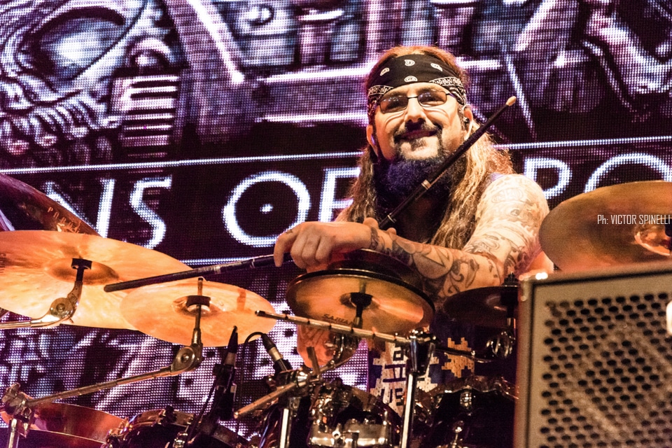 Sons of Apollo en Groove: el verdadero legado del Dios Sol - El supergrupo progresivo fundado por Mike Portnoy y Derek Sherinian visitó la Argentina para presentar “Psychotic Symphony”, su primer disco de estudio. Finalmente llegaron a nuestro país. Mike Portnoy (batería), Derek Sherinian (teclados), Billy Sheehan (bajo), Ron ‘Bumblefoot’ Thal (guitarra) y Jeff Scott Soto (voz) se presentaron por primera vez en la Argentina – es decir: todos juntos, como Sons of Apollo - para dar un show impecable, donde, además de presentar canciones de su disco de estudio, se permitieron coquetear con alguna que otra perlita del pasado. El concierto, que arrancó con “God of the Sun”, continuaría, sin pausas, con “Signs of Time”, “Figaro’s Whore” y “Divine Addiction, para meter, inmediatamente, el primer cover de la noche: “Just Let Me Breathe”, de Dream Theater. Con un quinteto ajustadísimo, siempre a la altura de las circunstancias, la banda recorrió de punta a punta, pero no en orden, su único álbum. Así, pasaron, fueron pasando “Labyrinth”, “Lost in Oblivion”, la hermosa cuasi balada “Alive”, y el monstruoso y épico instrumental de casi once minutos “Opus Maximus”. Como cabía esperar, todos tuvieron su protagónico, a solas, en el escenario (curiosamente, Portnoy fue el único sin número solista): Bumblefoot, con una divertida – y virtuosa, claro - versión del “Pink Panther Theme”; Soto jugando con el delay en un magistral a capella de “The Prophet’s Song” y una emotiva interpretación, junto al guitarrista, de “Save Me” (los dos, clásicos de Queen); Sheehan como irrefutable prueba de vida alienígena y, Sherinian, aprovechando el cien por ciento de sus bancos de sonidos para servir de preludio al que sería el momento más elevado de la velada, el del segundo cover: “Lines in the Sand”, - también de la ex banda de los fundadores -, con mención especial para el inquieto Bumblefoot que, en las botas del gran John Petrucci, supo poner la piel de gallina a toda la concurrencia con su fenomenal interpretación del conmovedor solo. Pero todo tiene un final. El gran cierre llegaría a dos horas del inicio, después de un brevísimo descanso: primero sonaría “And The Craddle Will Rock” (cover de Van Halen) y, ahora sí, definitivamente, la que estaba faltando del nuevo disco: “Coming Home”. Y, mientras los músicos, saludando atónitos ante la respuesta del público se preparaban para dejar el escenario, la ovación no encontraba punto final. Aristeo, Orfeo, Troilo, Eleuter, Coribantes, Asclepsio, Mileto, Anfiso son, según la mitología grecorromana, algunos de los hijos que Apolo, patrono de las bellas artes y la música, entre otras cosas, dejó en esta tierra. Mike, Derek, Billy, Ron y Jeff no aparecen en ninguna lista oficial. Aun así, permitámonos creer que solo se trata de un error: estos cinco tienen que ser hijos de Apolo. Si no, no se explica. Fotos: Víctor Spinelli 4eeada93 06d5 47cd 8b4f 360f3d5330f5