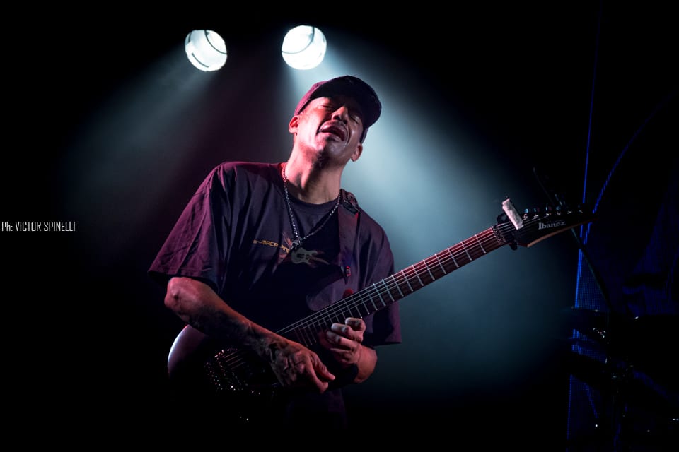 Tony Macalpine deslumbró en el Roxy - El guitarrista estadounidense llegó a la Argentina para presentar "Death of Roses", su disco más reciente. Si no proponemos pensar en guitarristas virtuosos, por lo menos al principio, nos vienen a la cabeza siempre los mismos tres o cuatro: Steve Vai, Joe Satriani, Yngwie Malmsteen, algunos de los más populares a nivel mundial, suelen ser los primeros en asaltar la memoria cuando repasamos el catálogo de maestros de las seis cuerdas. Sin embargo, hay muchos más, y Tony Macalpine en especial, está - a pesar de ser prácticamente un desconocido para el gran público - entre los más respetados y queridos tanto entre sus colegas como entre el público del estilo. Con quince discos solistas en su haber y un enorme inventario entre bandas full-time y colaboraciones con otros artistas, el guitarrista oriundo de Springfield, pionero del metal neo-clásico instrumental es, además, uno de los más prolíficos.
Luego de visitar nuestro país hace algunos años como parte de la banda en vivo de Steve Vai, Macalpine volvió a pisar suelo local, esta vez la primera vez en plan solista – ahora como trío, acompañado por los gigantes Pete Griffin (bajo) y Gergo Borlai (batería) -, para presentar su último trabajo de estudio y festejar, además, el cumpleaños número treinta de Maximum Security (1987), disco que, a fines de los 80, lo puso definitivamente en el podio junto a los mejores de su generación.
Y, a decir verdad, el apartado Death of Roses (2017) fue casi una excusa, un trámite para lo otro: rozando apenas el tracklist de su álbum número quince (sonaron “Chrome Castles”, “Death of Roses”, y alguna más del extenso archivo), el plato fuerte no fue otro que la interpretación, de punta a punta y con apenas alguna pausa para agradecer, del enorme Maximum Security. Así, desde pocos minutos después de comenzado el show, la emocionada audiencia disfrutó de clásicos como “Autumm Lords”, “Hundreds of Thounsands”, las tarareadas “Tears of Sahara” y “Keys to the City” o la preciosa “Porcellain Doll”.
A pesar de un volumen en ocasiones demasiado alto (contratiempo que, al parecer, se repitió en otras fechas del tour, como el Santiago ProgFest, en Chile) y que, por momentos, dificultaba incluso seguir las melodías, el saldo fue el de un show en todo sentido memorable. La visita del artista a tierras argentas dejó como resultado solo alegría y regocijo, abundantes vítores y cánticos de aliento, varios “una más y no jodemos más”, otros tantos “olé olé olé, Tony, Tony” y, sobre todo, grandes emociones, no solo por la performance, indudablemente impecable: es que, hace apenas tres años, el músico se vio obligado a suspender una gira al detectársele un agresivo cáncer del colon que lo tuvo, literalmente, más cerca del arpa que de la guitarra. Y hoy, quizás gracias a la divina intervención de Apolo (aunque más probablemente gracias a la oportuna práctica de algún también virtuoso profesional de la medicina), tuvimos la invaluable oportunidad de verlo y escucharlo, no solo en el mejor de los estados de salud, si no brindándose completamente a su público, en un concierto simplemente inolvidable. 9439ec4f eadd 4713 848e fdb712be730a