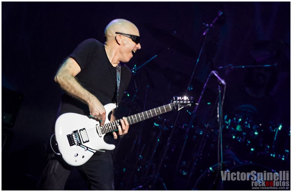 Joe Satriani volvió a la Argentina - Joe Satriani sabe de rock n' roll. Porque Joe Satriani no solo toca la guitarra, no solo ejecuta frases y ligados imposibles haciéndolos parecer la actividad humana más sencilla. No. Joe Satriani es quizás el único guitarrista de los llamados 'virtuosos' que ha logrado que sus piezas sean canciones: simples (y complicadas) canciones en las que esa guitarra que hace las veces de melodía principal puede ser, en cualquier momento, reemplazada por una voz cantante que probablemente transmitirá con palabras exactamente las mismas sensaciones que Satriani logra transmitir con su tenue caricia sobre las cuerdas. aace964c ac9c 4f34 9b97 90855b0794b3