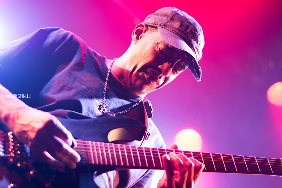 Tony Macalpine deslumbró en el Roxy - El guitarrista estadounidense llegó a la Argentina para presentar "Death of Roses", su disco más reciente. Si no proponemos pensar en guitarristas virtuosos, por lo menos al principio, nos vienen a la cabeza siempre los mismos tres o cuatro: Steve Vai, Joe Satriani, Yngwie Malmsteen, algunos de los más populares a nivel mundial, suelen ser los primeros en asaltar la memoria cuando repasamos el catálogo de maestros de las seis cuerdas. Sin embargo, hay muchos más, y Tony Macalpine en especial, está - a pesar de ser prácticamente un desconocido para el gran público - entre los más respetados y queridos tanto entre sus colegas como entre el público del estilo. Con quince discos solistas en su haber y un enorme inventario entre bandas full-time y colaboraciones con otros artistas, el guitarrista oriundo de Springfield, pionero del metal neo-clásico instrumental es, además, uno de los más prolíficos.
Luego de visitar nuestro país hace algunos años como parte de la banda en vivo de Steve Vai, Macalpine volvió a pisar suelo local, esta vez la primera vez en plan solista – ahora como trío, acompañado por los gigantes Pete Griffin (bajo) y Gergo Borlai (batería) -, para presentar su último trabajo de estudio y festejar, además, el cumpleaños número treinta de Maximum Security (1987), disco que, a fines de los 80, lo puso definitivamente en el podio junto a los mejores de su generación.
Y, a decir verdad, el apartado Death of Roses (2017) fue casi una excusa, un trámite para lo otro: rozando apenas el tracklist de su álbum número quince (sonaron “Chrome Castles”, “Death of Roses”, y alguna más del extenso archivo), el plato fuerte no fue otro que la interpretación, de punta a punta y con apenas alguna pausa para agradecer, del enorme Maximum Security. Así, desde pocos minutos después de comenzado el show, la emocionada audiencia disfrutó de clásicos como “Autumm Lords”, “Hundreds of Thounsands”, las tarareadas “Tears of Sahara” y “Keys to the City” o la preciosa “Porcellain Doll”.
A pesar de un volumen en ocasiones demasiado alto (contratiempo que, al parecer, se repitió en otras fechas del tour, como el Santiago ProgFest, en Chile) y que, por momentos, dificultaba incluso seguir las melodías, el saldo fue el de un show en todo sentido memorable. La visita del artista a tierras argentas dejó como resultado solo alegría y regocijo, abundantes vítores y cánticos de aliento, varios “una más y no jodemos más”, otros tantos “olé olé olé, Tony, Tony” y, sobre todo, grandes emociones, no solo por la performance, indudablemente impecable: es que, hace apenas tres años, el músico se vio obligado a suspender una gira al detectársele un agresivo cáncer del colon que lo tuvo, literalmente, más cerca del arpa que de la guitarra. Y hoy, quizás gracias a la divina intervención de Apolo (aunque más probablemente gracias a la oportuna práctica de algún también virtuoso profesional de la medicina), tuvimos la invaluable oportunidad de verlo y escucharlo, no solo en el mejor de los estados de salud, si no brindándose completamente a su público, en un concierto simplemente inolvidable. ba0c4047 a4d9 494c a704 da69427b6f23