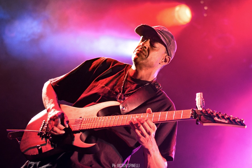 Tony Macalpine deslumbró en el Roxy - El guitarrista estadounidense llegó a la Argentina para presentar "Death of Roses", su disco más reciente. Si no proponemos pensar en guitarristas virtuosos, por lo menos al principio, nos vienen a la cabeza siempre los mismos tres o cuatro: Steve Vai, Joe Satriani, Yngwie Malmsteen, algunos de los más populares a nivel mundial, suelen ser los primeros en asaltar la memoria cuando repasamos el catálogo de maestros de las seis cuerdas. Sin embargo, hay muchos más, y Tony Macalpine en especial, está - a pesar de ser prácticamente un desconocido para el gran público - entre los más respetados y queridos tanto entre sus colegas como entre el público del estilo. Con quince discos solistas en su haber y un enorme inventario entre bandas full-time y colaboraciones con otros artistas, el guitarrista oriundo de Springfield, pionero del metal neo-clásico instrumental es, además, uno de los más prolíficos.
Luego de visitar nuestro país hace algunos años como parte de la banda en vivo de Steve Vai, Macalpine volvió a pisar suelo local, esta vez la primera vez en plan solista – ahora como trío, acompañado por los gigantes Pete Griffin (bajo) y Gergo Borlai (batería) -, para presentar su último trabajo de estudio y festejar, además, el cumpleaños número treinta de Maximum Security (1987), disco que, a fines de los 80, lo puso definitivamente en el podio junto a los mejores de su generación.
Y, a decir verdad, el apartado Death of Roses (2017) fue casi una excusa, un trámite para lo otro: rozando apenas el tracklist de su álbum número quince (sonaron “Chrome Castles”, “Death of Roses”, y alguna más del extenso archivo), el plato fuerte no fue otro que la interpretación, de punta a punta y con apenas alguna pausa para agradecer, del enorme Maximum Security. Así, desde pocos minutos después de comenzado el show, la emocionada audiencia disfrutó de clásicos como “Autumm Lords”, “Hundreds of Thounsands”, las tarareadas “Tears of Sahara” y “Keys to the City” o la preciosa “Porcellain Doll”.
A pesar de un volumen en ocasiones demasiado alto (contratiempo que, al parecer, se repitió en otras fechas del tour, como el Santiago ProgFest, en Chile) y que, por momentos, dificultaba incluso seguir las melodías, el saldo fue el de un show en todo sentido memorable. La visita del artista a tierras argentas dejó como resultado solo alegría y regocijo, abundantes vítores y cánticos de aliento, varios “una más y no jodemos más”, otros tantos “olé olé olé, Tony, Tony” y, sobre todo, grandes emociones, no solo por la performance, indudablemente impecable: es que, hace apenas tres años, el músico se vio obligado a suspender una gira al detectársele un agresivo cáncer del colon que lo tuvo, literalmente, más cerca del arpa que de la guitarra. Y hoy, quizás gracias a la divina intervención de Apolo (aunque más probablemente gracias a la oportuna práctica de algún también virtuoso profesional de la medicina), tuvimos la invaluable oportunidad de verlo y escucharlo, no solo en el mejor de los estados de salud, si no brindándose completamente a su público, en un concierto simplemente inolvidable. f0d33efa fb84 41e3 a0c7 2ff1ee62b154