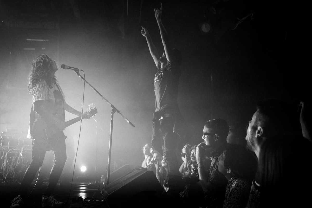 Utopians: post-parto, rock and roll y repudio a Cordera - Desde la última vez que Utopians tocó, en aquél Vorterix, pasó una eternidad. Por esos días el pequeño nuevo integrante de la banda se encontraba dentro de la panza de su mamá. Ahora a muy pocos meses de haber dado a luz retomaron el vivo y esta vez con un nuevo espectador y fanático número 1. Se murmuraba en los cortos silencios del show que "la maternidad le sentó bien", "debe ser el post-parto", la realidad nunca la sabremos pero lo cierto es que cada vez suenan mejor.
"Para nosotros es un milagro ver tanta gente, gracias a todos por venir es un sueño hecho realidad" Así se presentaba una de las
bandas de post-punk con mayor presente y futuro de la escena nacional, que cada vez llega a más oídos y crece de manera profesional permanentemente.
La noche del sábado era fría como casi todas las del mes de junio, el primer puntapié de Utopians fue con "Alimañas" y "Los ríos" ambas de su más reciente labor discográfica "Todos nuestros átomos".
El sucesor de "Vándalo" (2014) sigue una misma impronta pero con un sonido más afianzado y maduro. El show en vivo es potente. Prácticamente sin barreras entre el público y la banda, subidas y bajadas constantes al escenario, besos y abrazos a Barbi, guitarras imaginarias, mosh, pogo y más.
Los temas que siguieron eran un ping pong constante de los álbumes anteriores. Así pasaron "Trastornados", "Gris", "Algo Mejor", "Come baby", "Say Hello" y "Allá Voy" entre otras.
Un punto altamente emotivo se produjo cuando reversionaron "En Remolinos" del disco "Dynamo" (1992) de Soda Stereo. Durante el efusivo recital tuvieron algunos inconvenientes al romper un parche de la batería pero eso dio lugar al ingenio de Gus Fiocchi y Barbi Recanati que rápidamente tomaron sus instrumentos para realizar diversos covers hasta que el problema se solucionara. El invitado de honor fue Jimmy Rip, guitarrista de los míticos Television, quien produjo "Todos nuestros átomos", para tocar "Uhh", "Funeral" y "Las Arañas".
Antes de la despedida, Barbi en su rol de mujer y madre, se tomó unos minutos para reflexionar acerca de las presentaciones de Gustavo Cordera el próximo 15 y 16 en la misma sala. "Lo que dijo el señor Gustavo Cordera se condena. Amo este lugar y ojalá la semana que viene reflexionen", pero el repudio no quedó solo ahí: más tarde, una vez finalizado el show, un grupo de jóvenes se encontraría protestando en la puerta del local con leyendas como "Cordera sos la cultura de la violación" y "La Trastienda encubre violadores", reclamando que no se permitan los conciertos programados.
La despedida, luego de 90 minutos de puro rock y disfrute, llegó con la ya clásica interpretación de "Estallando desde el océano" de Sumo. Y a los eufóricos pedidos de seguir tocando, consultaron con los administradores del lugar, quienes les dijeron que tenían que entregar la sala. Utopians sigue demostrando, al igual que otras bandas, que el rumor de "que el rock está muerto" se reduce a tan solo eso, un rumor.
Fotos: Mercedes Cotoli 83ed79f1 8e9c 4cbd a8d3 18b4fe002db4