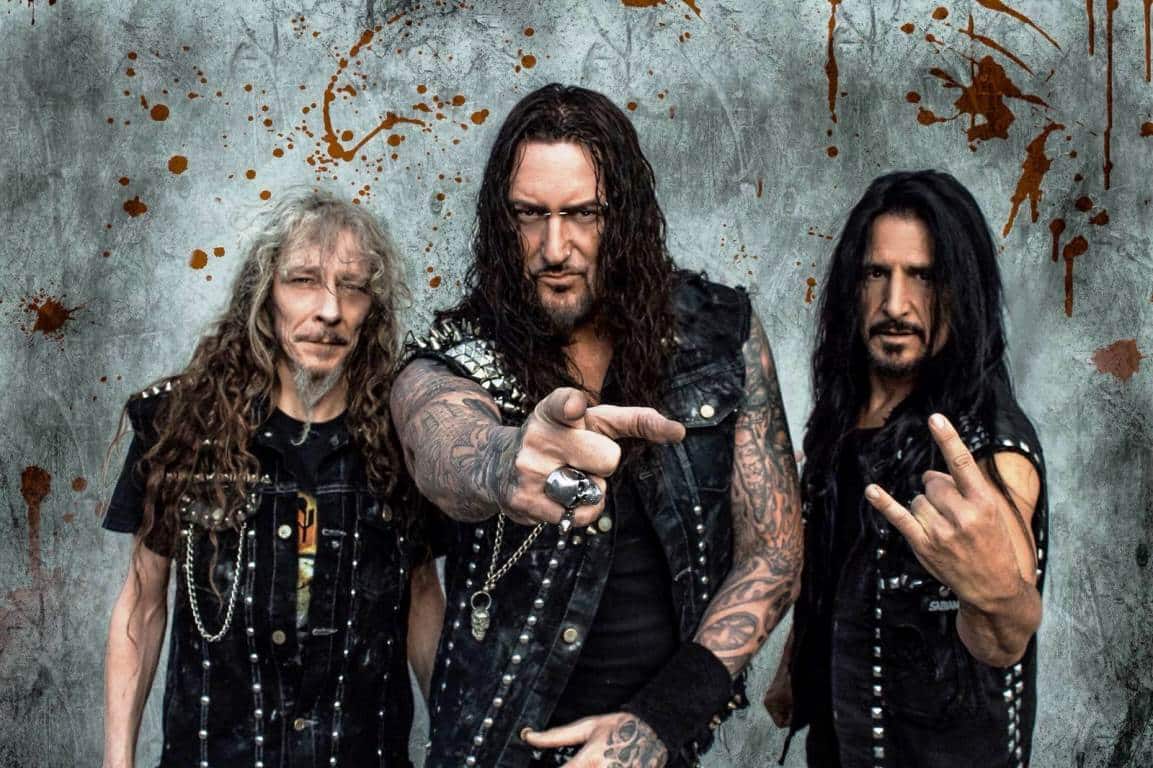 Destruction: "Las religiones siguen dividiéndonos y generando odio" - Schmier critica los dogmas y recuerda cuando un acosador dijo ser su hermano. También explica por qué lleva toneladas de medicamentos en cada gira, y anticipa el show de septiembre en el Teatro Vorterix. "Tuve muchos fans hostigadores: uno de ellos les contó a todos que era mi hermano y se metió en las redes a contactar a mis conocidos. Lo peor fue que, con ese pretexto, se mudó a la casa de un amigo en Noruega. Le advirtió: ‘No le cuentes a Schmier, porque aunque somos familiares tenemos problemas’. Hasta que un día mi amigo me llamó y me contó la situación, y le expliqué que era imposible, porque mi verdadero hermano vivía en Alemania -relata Marcel "Schmier" Schirmer, cantante y bajista de Destruction-. Encima inventó un montón de mierdas sobre mí en revistas y portales, y llamó a un restaurante que tenía. Les dijo que era de mi discográfica y que necesitaba hablar conmigo, así que los mozos le dieron mi número. Desde entonces, me llamó diez veces por día".
Aunque parezca una historia de película, estas situaciones son más que comunes en el mundo de la música, y el metal extremo no está exento. Mucho menos si sacaste una quincena de discos y formás parte del Big 4 del thrash alemán junto a Kreator, Sodom y Tankard."Tuve que cambiar de teléfono y todo… ¡fue muy difícil! A pesar de eso, aprendí que a los stalkers tenés que ignorarlos. Es gente con problemas psicológicos, pero pueden generarte líos inmensos. Supongo que es parte del precio de tocar en una banda", agrega. Tal situación llevó a Schmier -que comanda Destruction desde 1982- a escribir "Second to none", que apareció en "Under Attack" (2016), su último disco de estudio con canciones inéditas. "La letra es muy importante porque muchos ignoran que internet es una herramienta muy poderosa para insultar, por ejemplo. Hay gente que se suicida por esos comentarios, así que es una situación muy triste", completa desde el otro lado de la línea.
-Imagino que tu falso hermano ya está en la cárcel…
-No. Les dije a todos que era un acosador y que lo ignoraran, y la mayoría lo hizo. Todavía está tratando de contactarme, y cada tanto me manda un mensaje por Facebook o por Instagram. Me escribe: "Por favor, seamos amigos. Perdoname por lo que hice, estoy muy apenado". A mí me gusta ser bueno con la gente, pero no podés dar el brazo a torcer con tipos así. No es lo que quiero para mi vida, y trato de mantenerlo alejado. Ojalá que algún día encuentre su propio rumbo.
-Otra de las canciones destacadas de "Under Attack" es "Elegant pigs", que habla de las bandas que tocan con miles de pistas de fondo. ¿Siendo un trío, es difícil "competirles" sin backing tracks?
-Destruction hoy por hoy tiene el mejor lineup de su historia -se refiere al co-fundador Mike Sifringer en guitarra y al baterista Randy Black-, y estamos muy ajustados. En vivo hay un montón de energía cruda y talento, y nuestro sonido es honesto. Algunos grupos pueden sonar como en los discos, ¿pero cuál es el sentido? Si es un recital, la onda es brindar una propuesta distinta y dar una performance más provocadora. Cuando una banda suena tan prolija, tenés que pensar que capaz tengan diez pistas de fondo. Es muy triste, y aunque el rock siempre fue honesto, ahora hay un montón de mentirosos. El año pasado hubo un escándalo con Michael Kiske, de Helloween, en México. Ellos explicaron que usaron los tracks porque él estaba enfermo, pero mi pregunta es… ¿por qué el tipo va de gira con pistas grabadas? Hoy es muy fácil ser un estafador, y yo no quiero eso para Destruction. Hace poco vi a Judas Priest y a Iron Maiden, y no usan pistas. Siguen tocando todo, y esa es la verdadera esencia de la música para mí. -En "Under attack" volviste a pegarle a la religión. ¿Notás cambios dogmáticos entre la época vieja y la actual?
-Sí, pero la situación no mejoró, sino que empeoró. La primera canción religiosa que escribimos fue "Curse the gods", donde mencionamos a Alá, a Buda y a Jesucristo. Nosotros nos criamos en una zona muy religiosa de Alemania, y crecimos con principios conservadores. Por eso tratamos de salir de ese mundillo cuando éramos jóvenes. Los problemas en Europa se agudizaron porque llegan montón de inmigrantes desde países musulmanes, y hay líos entre ellos y los cristianos. Ocurre porque tienen diferentes creencias, y eso me demuestra que la mierda dogmática sigue separando a la gente. Vivimos todos en el mismo planeta, pero las religiones dividen a todas las naciones y esparcen el odio. Por eso creo que la situación empeoró.
Schmier le levanta el dedo a los acosadores. HIMNOS DEL THRASH, PARTE IILa histórica banda alemana lanzó "Thrash Anthems II", un disco con regrabaciones de viejas canciones, en 2017. Diez años antes ya habían editado el primer volumen de la saga, pero esta vez decidieron ir más allá: a gran parte de los temas los eligieron los fans. Uno de ellos fue "Frontbeast", una rareza que sólo había aparecido en un demo.
"En ese sentido, no fue tan sorpresivo que la gente haya querido oírla de nuevo. Nosotros no estábamos tan seguros de que fuera lo suficientemente buena, así que tuvimos que reaprenderla y ver si funcionaba. Cuando armás algo junto a tus fans, es importante que tanto ellos como vos queden conformes. Al tocar una canción, es esencial sentirla en la piel. Asombrosamente, eso ocurrió cuando la rehicimos -explica Schmier en un inglés con dejos de alemán-. Tiene un feeling punk y crudo, y por eso nos gusta. Obvio que también había un montón de cosas que no habíamos escuchado en varios años, como ‘United by hatred’ y ‘Black mass’. A esta última no la habíamos tocado en más de tres décadas". -Lo gracioso fue que no recordabas las letras de temas como "Frontbeast" y "Black mass", por lo que tuviste que llamar al exbaterista de Destruction y pedírselas...
-Exactamente, esa es la historia (se ríe). En internet estaban mal, y los primeros discos no las traían escritas. Así que Tommy Sandmann buscó en su sótano y encontró los manuscritos originales. Fue muy gracioso porque no pensé que él guardara eso, pero tenía incluso ropas viejas y nuestro primer contrato discográfico. También descubrimos que la letra de "Frontbeast" era mucho más larga. A veces necesitás ayuda para recordar ciertas cosas, y más si compusiste esos temas hace 35 años. ¡Yo tenía 16! Al tocarlas en vivo las retenés en tu memoria, pero con éstas fue más complicado. Esos objetos son parte de la historia de la banda, y algún día hasta deberíamos hacer un museo de Destruction.
-Claro, o un box set incluyendo ese material. -Sí, estaría muy bueno. No lo hicimos todavía, pero hace poco relanzamos nuestros primeros siete álbumes. Semejantes archivos serían muy interesantes para un box.
La primera formación de Destruction no le tenía miedo a las tumbas profanadas.
-Hace unos años hicieron un tour con Candlemass, y dijiste que fue horrible. ¿Qué pasó?
-Amo a la banda y a Messiah, su excantante. Nosotros estábamos a full, con una gira europea por delante, y los teloneros se habían caído. Así que los llamamos a porque somos amigos, y pensamos: "¿Y si juntamos ambos géneros? En los festivales, los fans siempre están abiertos a estas cosas". Pero por esa razón, los seguidores de Candlemass no fueron a esos shows... y lo mismo pasó con los nuestros. Así que el tour tuvo muy poco público y fue una audiencia rara. Los miembros de Candlemass estaban muy apenados porque casi no vendían merchandising, y para mí fue horrible porque pensaba que en el metal había una comunidad más unida. Es obvio que el doom y el thrash están en diferentes extremos, ¡pero yo soy thrasher y me gusta Candlemass! Los reacios eran más que nada los fans del doom, que decían "no quiero ver a Destruction, tocan demasiado rápido". Esa fue una gran lección para mí: hay que elegir inteligentemente a los grupos soportes. Personalmente fue una gira genial, pero no en cuanto a todo lo demás.
¿Automedicarse? ¡Obvio que sí!
EL MÉDICO DEL METAL-Tus amigos te dicen "Doctor Schmier", porque siempre viajás con un montón de medicamentos y hasta cosas para controlar la presión arterial. ¡Incluso una vez auxiliaste a Overkill! ¿En qué otras situaciones te fue útil?
-(Estalla a carcajadas). En los tours nos puede pasar de todo, así que desde joven tengo aspirinas, antibióticos y penicilina. Por ejemplo, sirven si tenemos una infección en la garganta y se nos complica cantar. Así que empecé a "coleccionar" material, porque cuando envejecés vas llevando más y más cosas. Al principio salvé a un montón de mis amigos dándoles preservativos, porque andaban "divirtiéndose" con personas extrañas mientras sus novias estaban esperándolos en casa, así que no llevaban protección. ¡Salvé a un montón de personajes del heavy metal de que no se contagiaran enfermedades de transmisión sexual! Pero en general llevo todo eso para ayudar a mis compañeros, a la gente de la crew y a las demás bandas. Estando de gira, siempre me preocupo por la "familia". Hace dos años, en un tour por los Estados Unidos, me corté muy profundamente el dedo y no tenía nada para arreglarlo. Así que yo mismo tuve que volver a ponerlo en su lugar. ¡Fue terrible! Parecía Rambo, y definitivamente no estaba preparado para eso (risas). -Ojalá no tengas esos problemas en la Argentina. ¿Cómo va a ser el setlist del show del Teatro Vorterix?
-Vamos a hacer canciones de "Thrash Anthems II", clásicos y temas que no tocamos allá antes -el grupo vino por última vez en 2011-. Obviamente van a haber cosas de "Under Attack", así que será una gran mezcla. Durará entre una hora y media y dos; va a ser un recital largo y con sorpresas. En la Argentina pasa algo distinto del resto del mundo, porque ustedes cantan los riffs. Es algo único, y nadie más lo hace. Así que estoy ansioso por volver allá.
-¿Vas a venir con tu farmacia portátil de medicamentos?
-¡Obvio! Cuando vayamos a Sudamérica voy a llevar antibióticos para el estómago, porque muchos tienen problemas con eso cuando van a un país desconocido. También pastillas para la diarrea y otras para no apunarnos en las zonas de mayor altitud. En general me armo botiquines personalizados para cada gira. Los de la aduana me miran muy mal porque me ven con una valija llena de pastillas y medicamentos, pero es por la seguridad de todos. ¡Por lo general, en mis tours nadie se enferma! (risas).
Destruction tocará el sábado 29 de septiembre en el Teatro Vorterix (Av. Lacroze 3455). Las anticipadas cuestan $900 más costo de servicio, y se consiguen a través de AllAccess. 8e4b4246 ae18 47d7 b592 d28cfec8f5c4