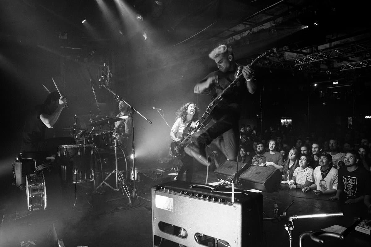 Utopians: post-parto, rock and roll y repudio a Cordera - Desde la última vez que Utopians tocó, en aquél Vorterix, pasó una eternidad. Por esos días el pequeño nuevo integrante de la banda se encontraba dentro de la panza de su mamá. Ahora a muy pocos meses de haber dado a luz retomaron el vivo y esta vez con un nuevo espectador y fanático número 1. Se murmuraba en los cortos silencios del show que "la maternidad le sentó bien", "debe ser el post-parto", la realidad nunca la sabremos pero lo cierto es que cada vez suenan mejor.
"Para nosotros es un milagro ver tanta gente, gracias a todos por venir es un sueño hecho realidad" Así se presentaba una de las
bandas de post-punk con mayor presente y futuro de la escena nacional, que cada vez llega a más oídos y crece de manera profesional permanentemente.
La noche del sábado era fría como casi todas las del mes de junio, el primer puntapié de Utopians fue con "Alimañas" y "Los ríos" ambas de su más reciente labor discográfica "Todos nuestros átomos".
El sucesor de "Vándalo" (2014) sigue una misma impronta pero con un sonido más afianzado y maduro. El show en vivo es potente. Prácticamente sin barreras entre el público y la banda, subidas y bajadas constantes al escenario, besos y abrazos a Barbi, guitarras imaginarias, mosh, pogo y más.
Los temas que siguieron eran un ping pong constante de los álbumes anteriores. Así pasaron "Trastornados", "Gris", "Algo Mejor", "Come baby", "Say Hello" y "Allá Voy" entre otras.
Un punto altamente emotivo se produjo cuando reversionaron "En Remolinos" del disco "Dynamo" (1992) de Soda Stereo. Durante el efusivo recital tuvieron algunos inconvenientes al romper un parche de la batería pero eso dio lugar al ingenio de Gus Fiocchi y Barbi Recanati que rápidamente tomaron sus instrumentos para realizar diversos covers hasta que el problema se solucionara. El invitado de honor fue Jimmy Rip, guitarrista de los míticos Television, quien produjo "Todos nuestros átomos", para tocar "Uhh", "Funeral" y "Las Arañas".
Antes de la despedida, Barbi en su rol de mujer y madre, se tomó unos minutos para reflexionar acerca de las presentaciones de Gustavo Cordera el próximo 15 y 16 en la misma sala. "Lo que dijo el señor Gustavo Cordera se condena. Amo este lugar y ojalá la semana que viene reflexionen", pero el repudio no quedó solo ahí: más tarde, una vez finalizado el show, un grupo de jóvenes se encontraría protestando en la puerta del local con leyendas como "Cordera sos la cultura de la violación" y "La Trastienda encubre violadores", reclamando que no se permitan los conciertos programados.
La despedida, luego de 90 minutos de puro rock y disfrute, llegó con la ya clásica interpretación de "Estallando desde el océano" de Sumo. Y a los eufóricos pedidos de seguir tocando, consultaron con los administradores del lugar, quienes les dijeron que tenían que entregar la sala. Utopians sigue demostrando, al igual que otras bandas, que el rumor de "que el rock está muerto" se reduce a tan solo eso, un rumor.
Fotos: Mercedes Cotoli aec2ba10 5ab4 48e1 8183 615c0ea14d62