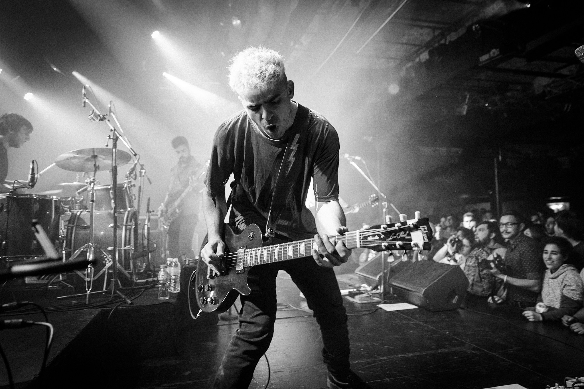 Utopians: post-parto, rock and roll y repudio a Cordera - Desde la última vez que Utopians tocó, en aquél Vorterix, pasó una eternidad. Por esos días el pequeño nuevo integrante de la banda se encontraba dentro de la panza de su mamá. Ahora a muy pocos meses de haber dado a luz retomaron el vivo y esta vez con un nuevo espectador y fanático número 1. Se murmuraba en los cortos silencios del show que "la maternidad le sentó bien", "debe ser el post-parto", la realidad nunca la sabremos pero lo cierto es que cada vez suenan mejor.
"Para nosotros es un milagro ver tanta gente, gracias a todos por venir es un sueño hecho realidad" Así se presentaba una de las
bandas de post-punk con mayor presente y futuro de la escena nacional, que cada vez llega a más oídos y crece de manera profesional permanentemente.
La noche del sábado era fría como casi todas las del mes de junio, el primer puntapié de Utopians fue con "Alimañas" y "Los ríos" ambas de su más reciente labor discográfica "Todos nuestros átomos".
El sucesor de "Vándalo" (2014) sigue una misma impronta pero con un sonido más afianzado y maduro. El show en vivo es potente. Prácticamente sin barreras entre el público y la banda, subidas y bajadas constantes al escenario, besos y abrazos a Barbi, guitarras imaginarias, mosh, pogo y más.
Los temas que siguieron eran un ping pong constante de los álbumes anteriores. Así pasaron "Trastornados", "Gris", "Algo Mejor", "Come baby", "Say Hello" y "Allá Voy" entre otras.
Un punto altamente emotivo se produjo cuando reversionaron "En Remolinos" del disco "Dynamo" (1992) de Soda Stereo. Durante el efusivo recital tuvieron algunos inconvenientes al romper un parche de la batería pero eso dio lugar al ingenio de Gus Fiocchi y Barbi Recanati que rápidamente tomaron sus instrumentos para realizar diversos covers hasta que el problema se solucionara. El invitado de honor fue Jimmy Rip, guitarrista de los míticos Television, quien produjo "Todos nuestros átomos", para tocar "Uhh", "Funeral" y "Las Arañas".
Antes de la despedida, Barbi en su rol de mujer y madre, se tomó unos minutos para reflexionar acerca de las presentaciones de Gustavo Cordera el próximo 15 y 16 en la misma sala. "Lo que dijo el señor Gustavo Cordera se condena. Amo este lugar y ojalá la semana que viene reflexionen", pero el repudio no quedó solo ahí: más tarde, una vez finalizado el show, un grupo de jóvenes se encontraría protestando en la puerta del local con leyendas como "Cordera sos la cultura de la violación" y "La Trastienda encubre violadores", reclamando que no se permitan los conciertos programados.
La despedida, luego de 90 minutos de puro rock y disfrute, llegó con la ya clásica interpretación de "Estallando desde el océano" de Sumo. Y a los eufóricos pedidos de seguir tocando, consultaron con los administradores del lugar, quienes les dijeron que tenían que entregar la sala. Utopians sigue demostrando, al igual que otras bandas, que el rumor de "que el rock está muerto" se reduce a tan solo eso, un rumor.
Fotos: Mercedes Cotoli b010d596 92f9 422a 97d8 c01a82b62922